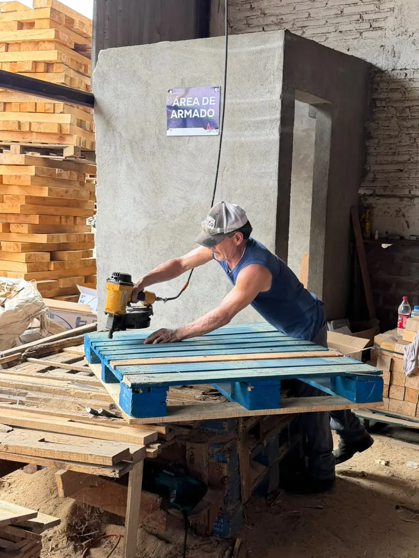 Trabajador de Tarimas Garo armando una tarima de madera con clavadora neumática en el área de armado, Puebla